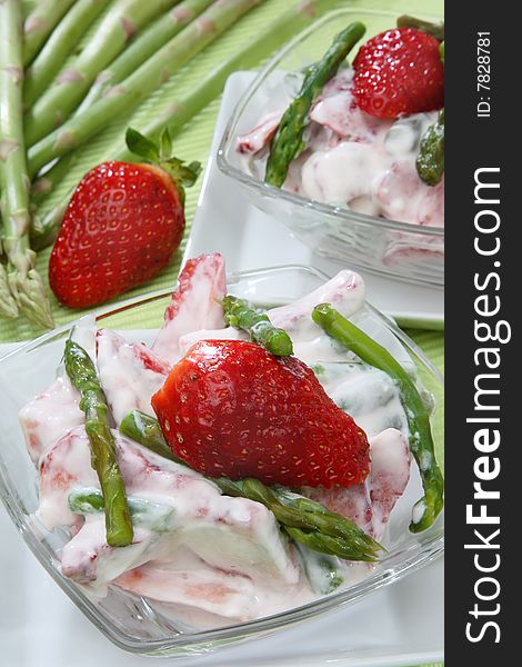 Fresh strawberries in white cream with green aspar