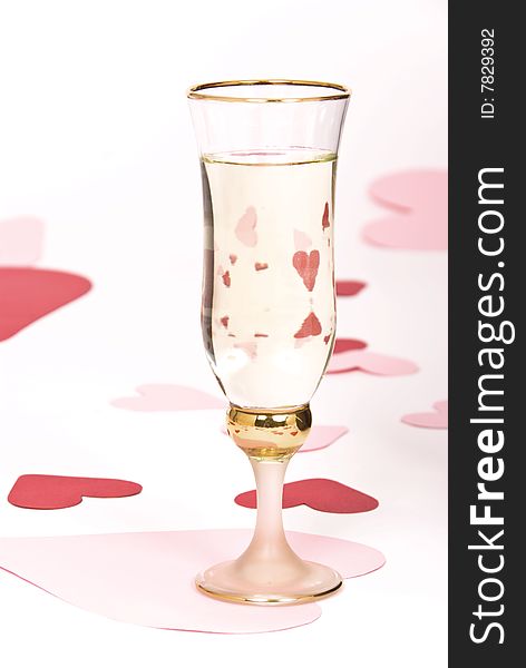 Glass of white wine on white heart covered background