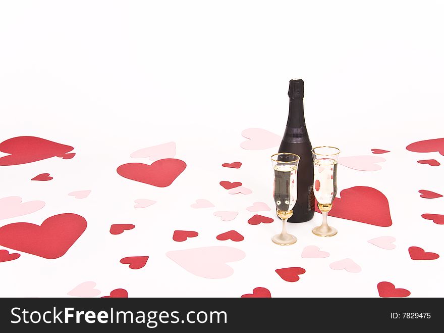 Two glasses  of white wine on white heart covered background