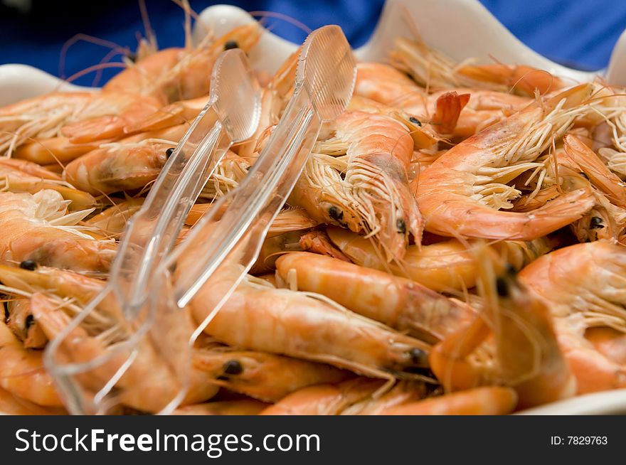 Fresh king prawns recipient with tweezers