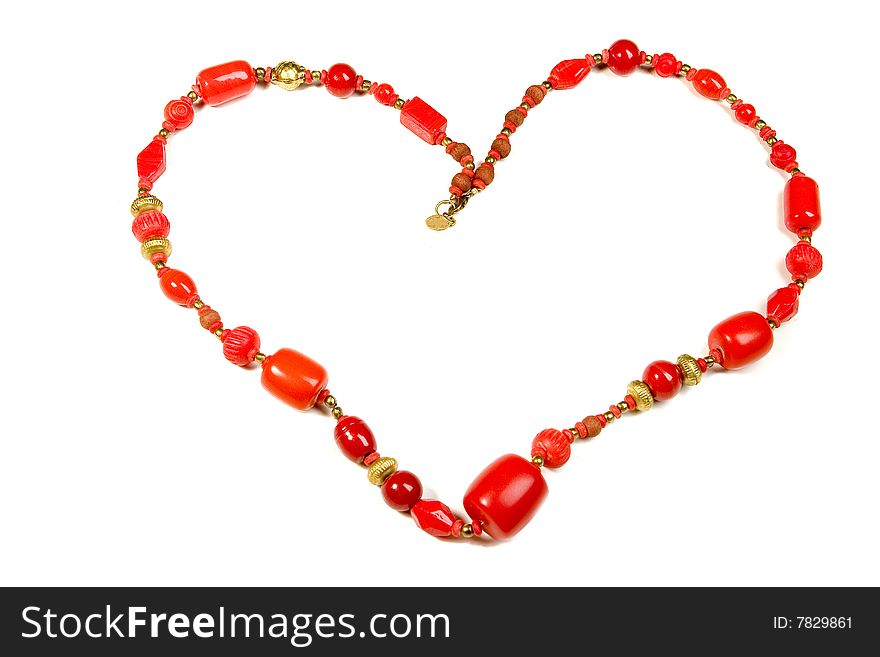 Heart made of red necklace on white ground