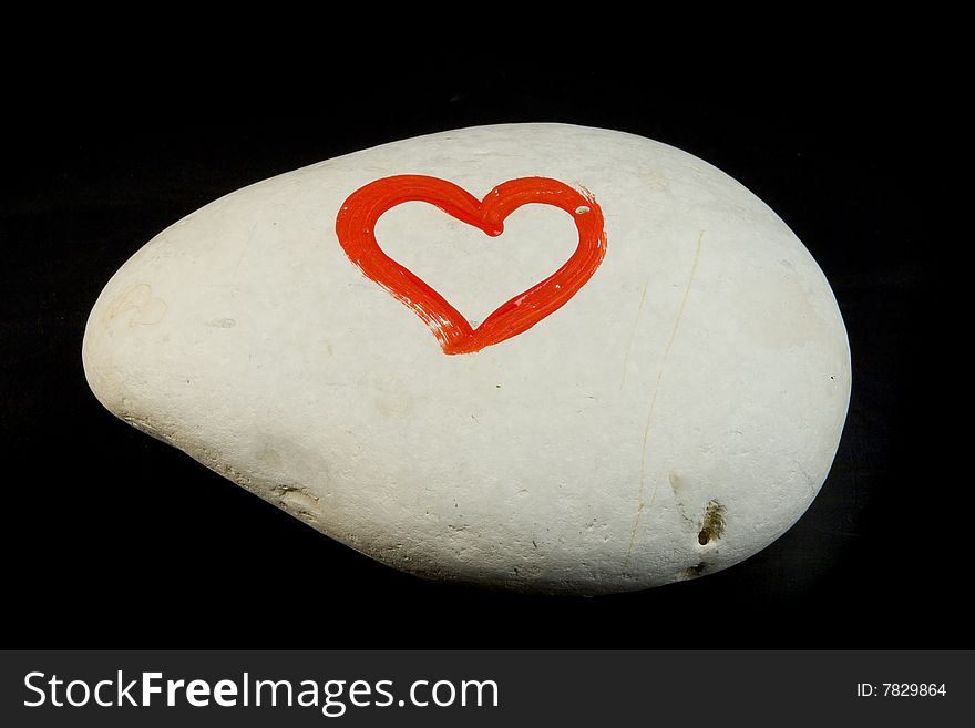 Heart on white stone on black ground