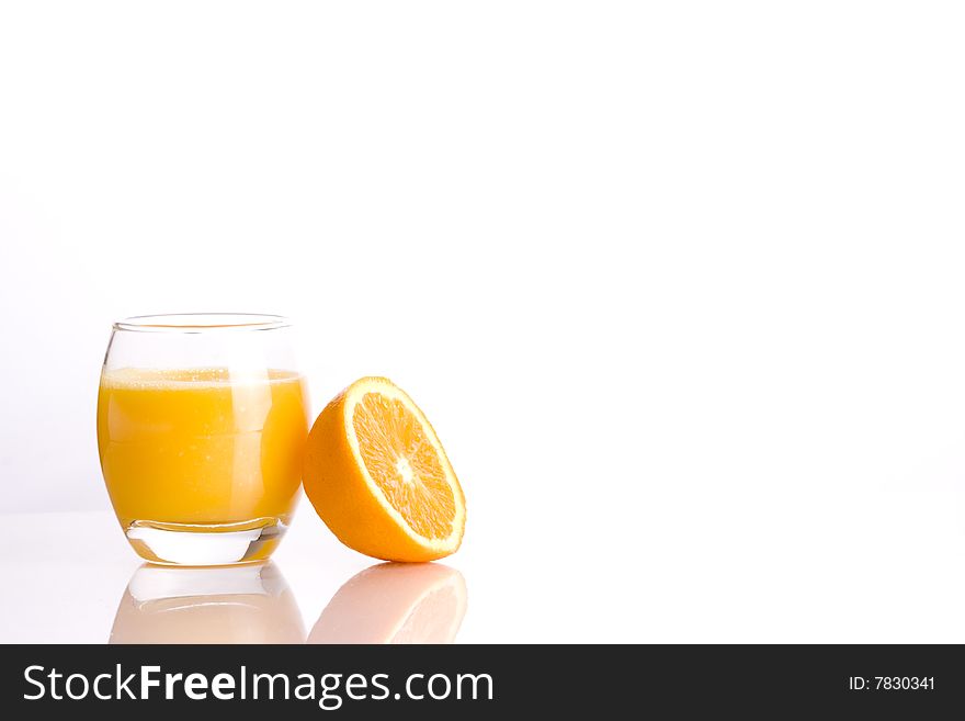 Composition of a glass with a refreshing orange´s juice and the half of a orange. Composition of a glass with a refreshing orange´s juice and the half of a orange