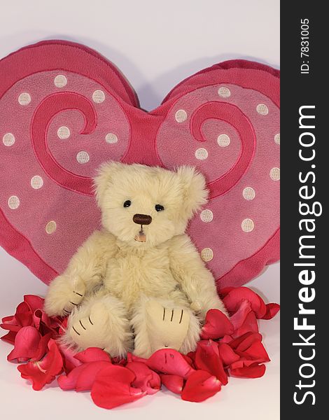 Teddy bear close to a heart with rose petals. Teddy bear close to a heart with rose petals