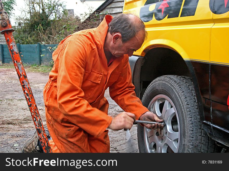 Mechanic changing wheel on van