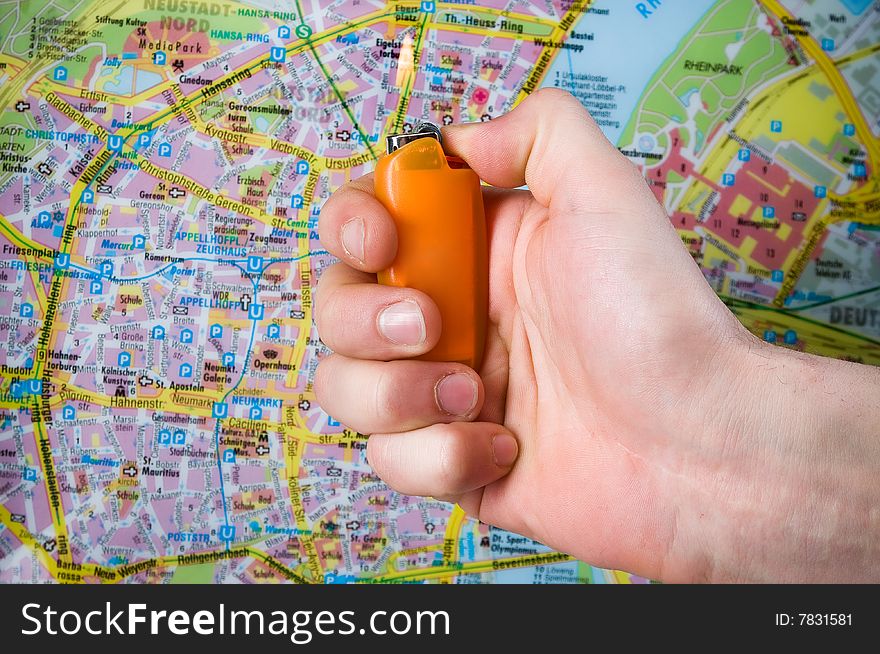 Hand with lighter over blurred map. Hand with lighter over blurred map