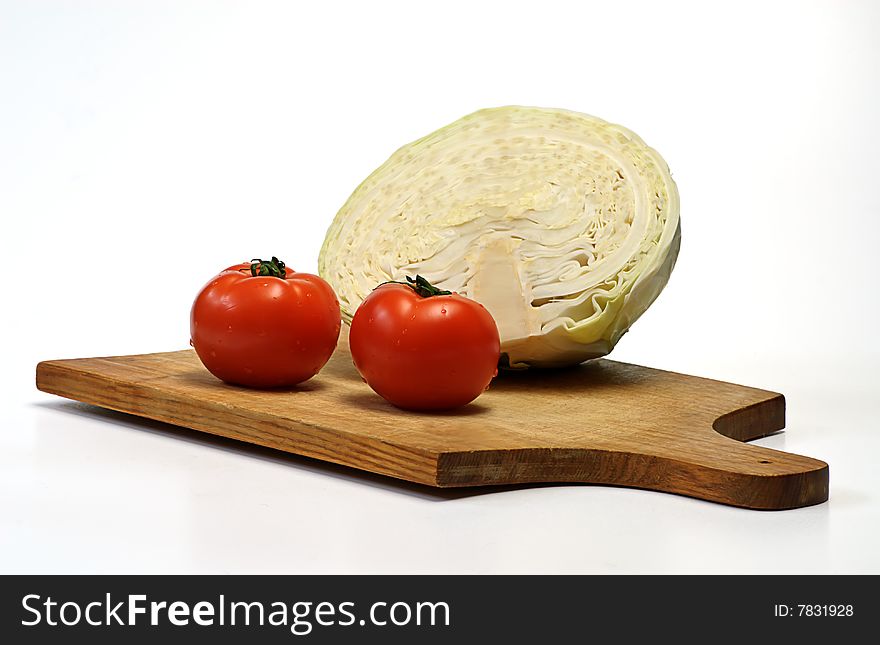 Cabbage and tomato on wooden plate