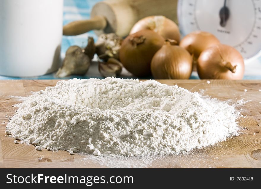 White flour laying on wooden board with ingredients. White flour laying on wooden board with ingredients