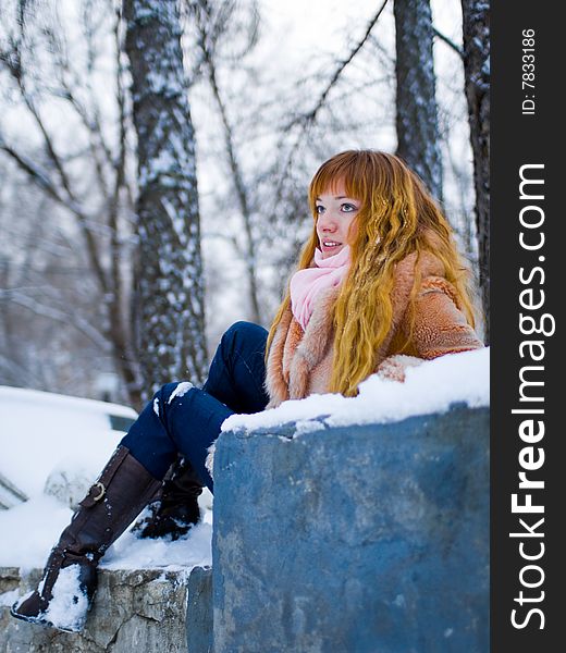 Red-heared girl in short fur coat outdoors - shallow DOF. Red-heared girl in short fur coat outdoors - shallow DOF