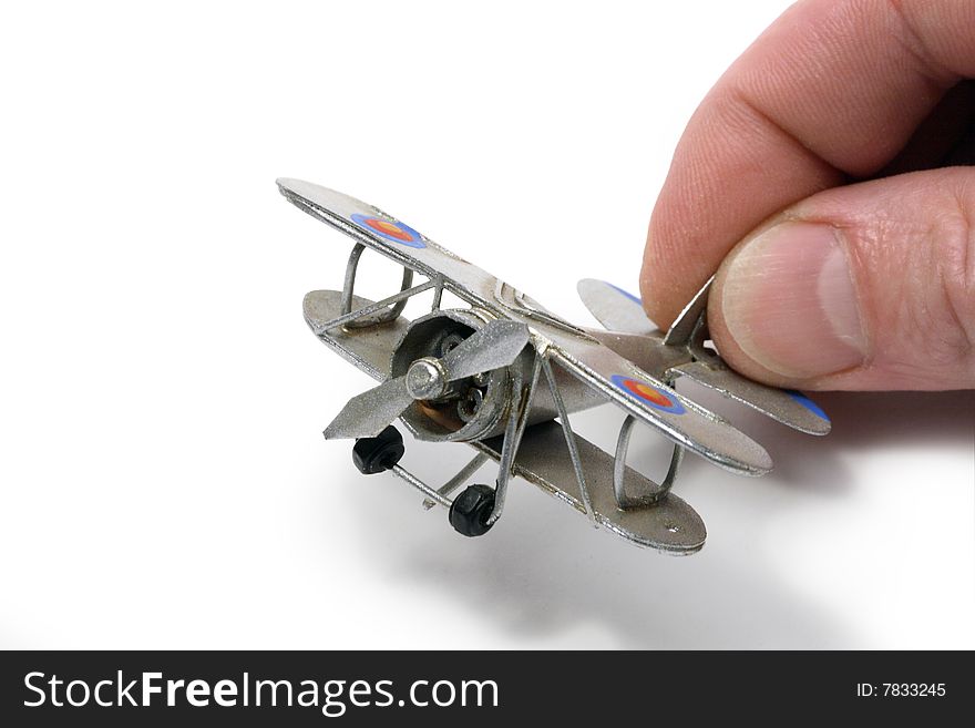Isolated man hand holding a small model of silver ancient plane. Isolated man hand holding a small model of silver ancient plane
