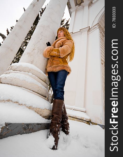 Red-heared girl in short fur coat outdoors - wide angle portrait. Red-heared girl in short fur coat outdoors - wide angle portrait