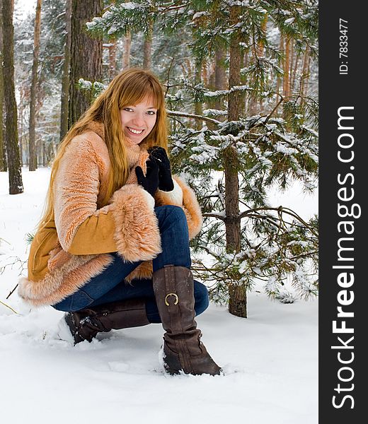 Red-heared girl in short fur coat outdoors. Red-heared girl in short fur coat outdoors