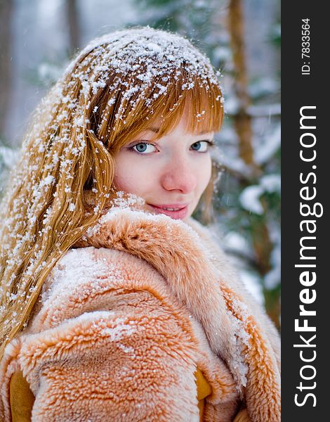 Red-heared girl in fur coat outdoors - shallow DOF. Red-heared girl in fur coat outdoors - shallow DOF