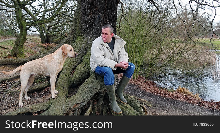 Man and yellow labrador puppy in the forest. Man and yellow labrador puppy in the forest