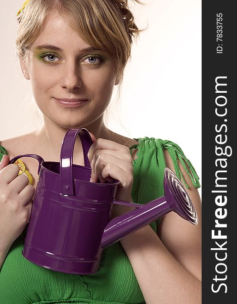 Woman keeps purple watering can. Woman keeps purple watering can