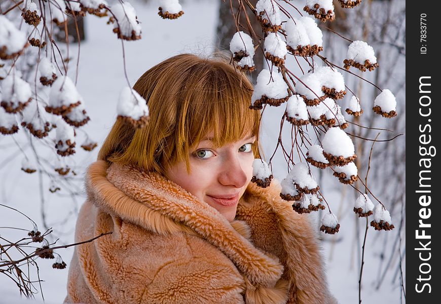 Red-heared girl in fur coat outdoors - shallow DOF. Red-heared girl in fur coat outdoors - shallow DOF