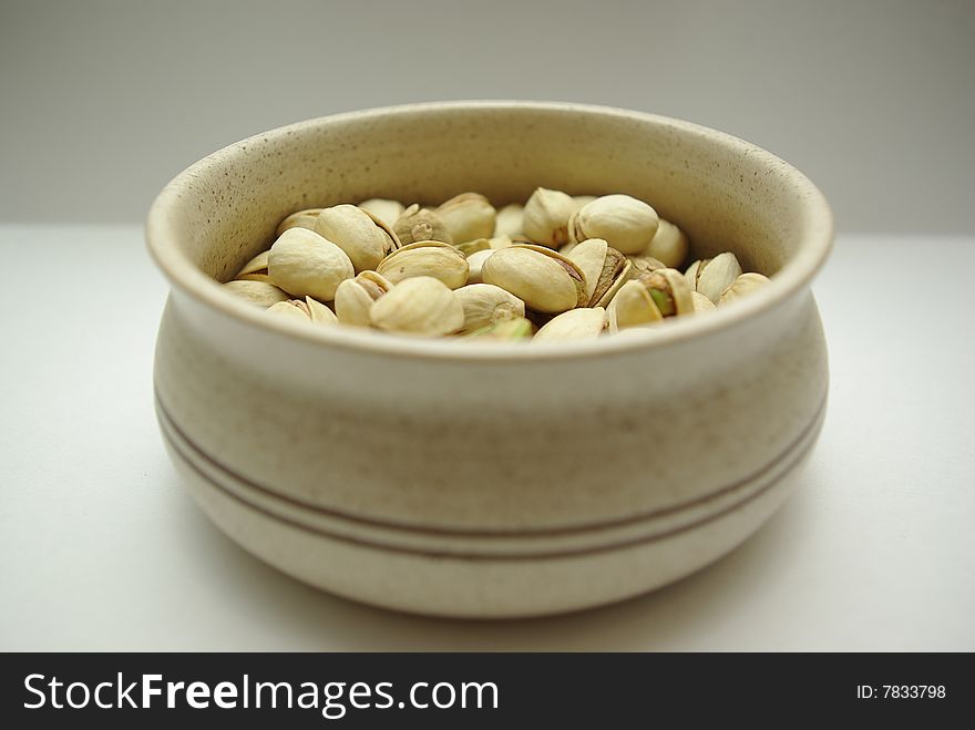 Pistachio quotations in ceramic saucer, ready to food. Pistachio quotations in ceramic saucer, ready to food.
