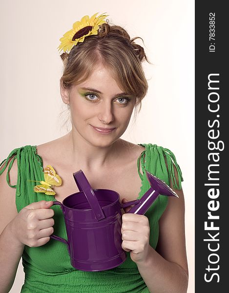 Woman keeps purple watering can. Woman keeps purple watering can