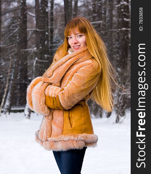 Red-heared girl in short fur coat outdoors - shallow DOF. Red-heared girl in short fur coat outdoors - shallow DOF