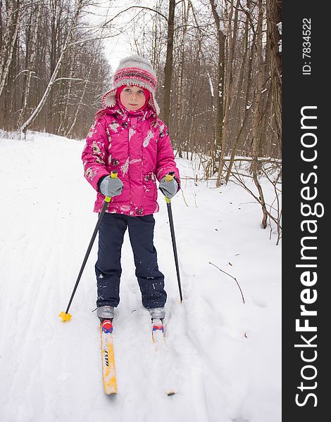 5 years old girl cross-country skiing in a forest