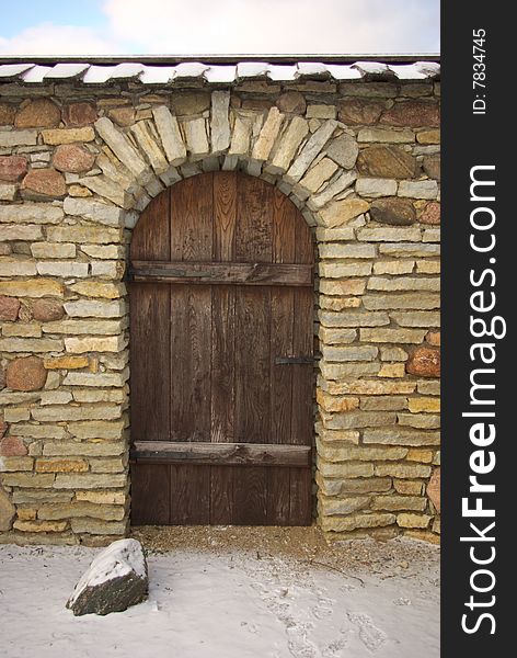 Wooden old door in strong stone wall. Wooden old door in strong stone wall.