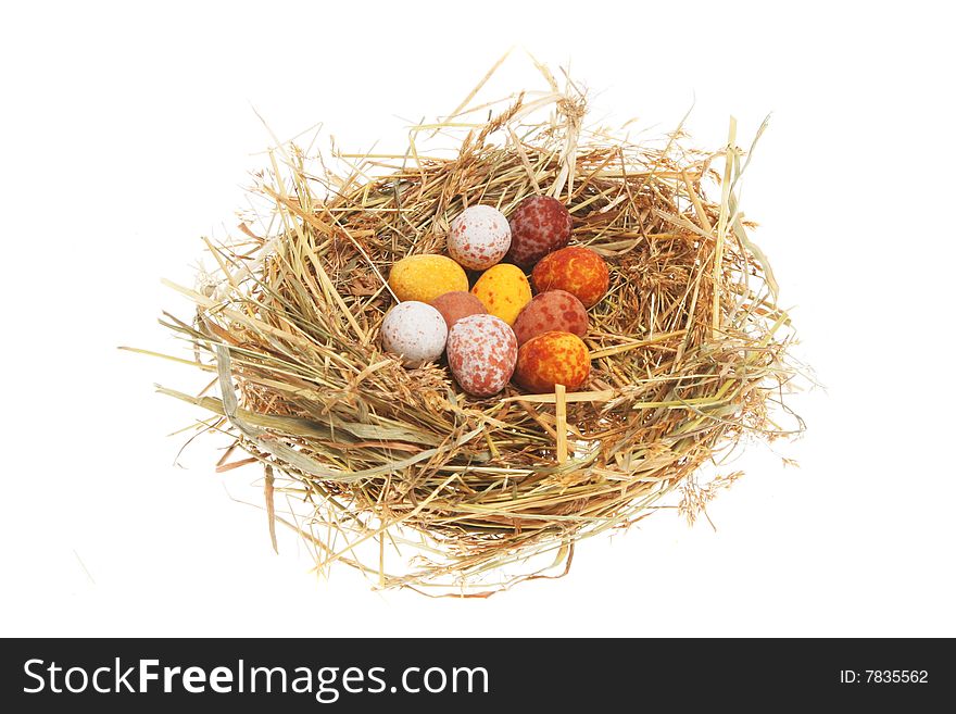 Miniature Easter eggs in a straw nest. Miniature Easter eggs in a straw nest