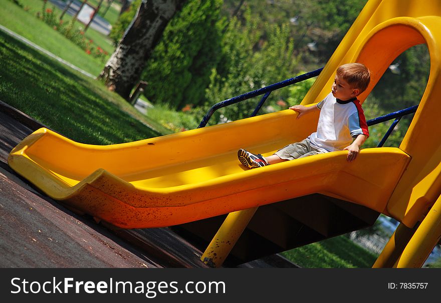 Boy on a yellow slide. Boy on a yellow slide