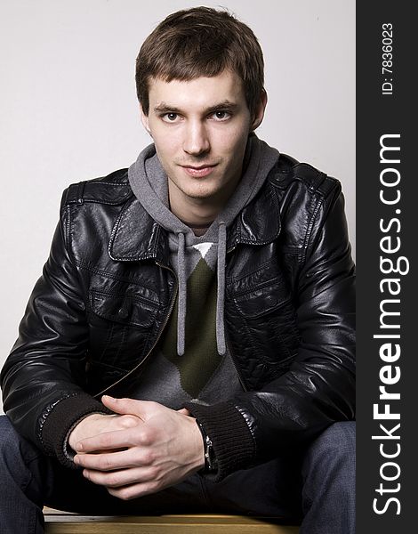 Portrait of a handsome young man sitting on the bench