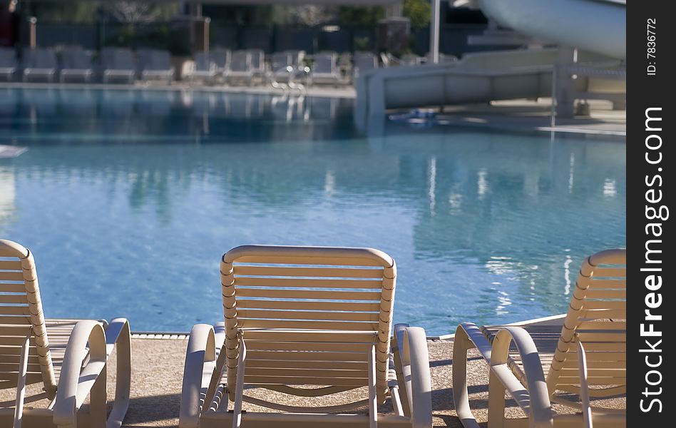 Sun chairs and water slide by large wimming pool. Sun chairs and water slide by large wimming pool