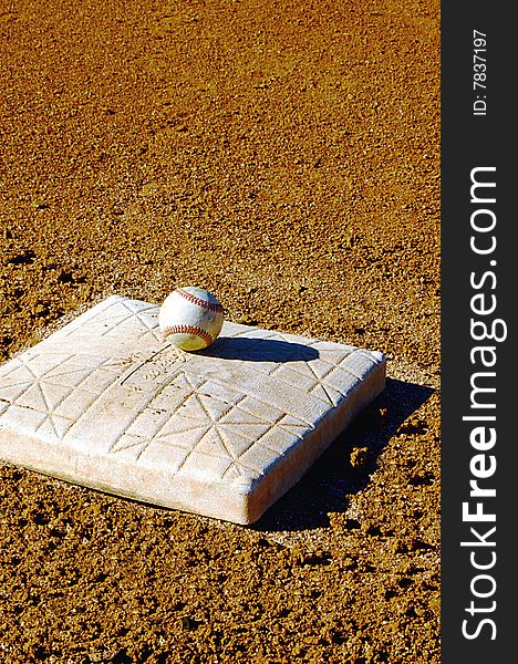 Baseball sitting on top of base in stadium. Baseball sitting on top of base in stadium.