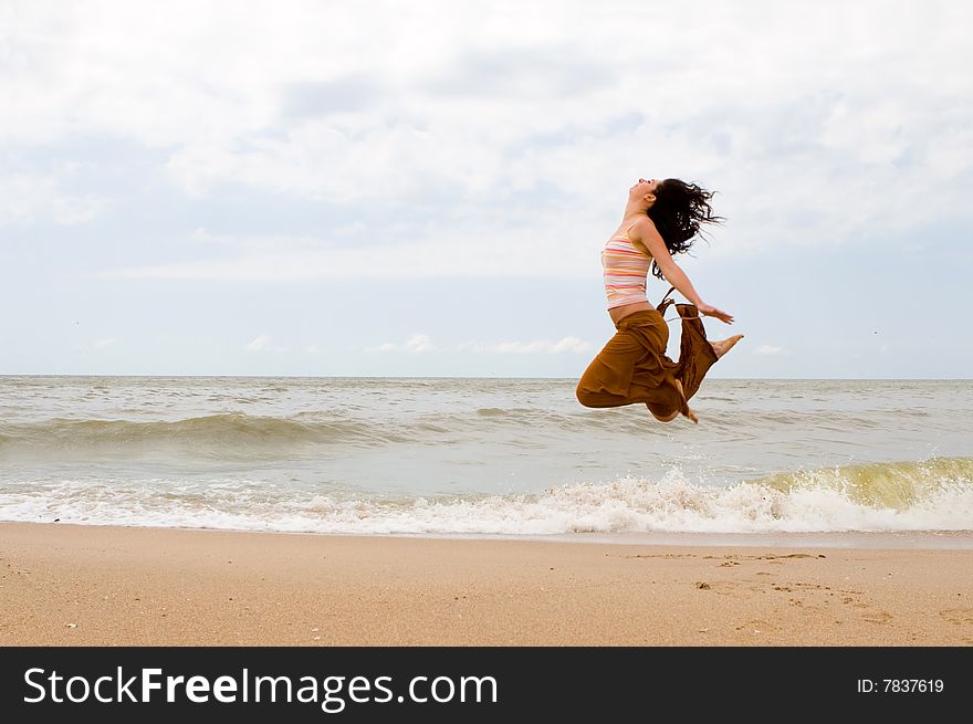 Happy woman is jumping in beach