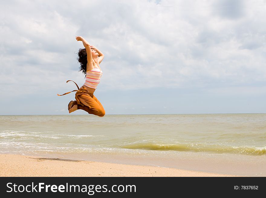 Happy young woman is jumping in beach. Happy young woman is jumping in beach