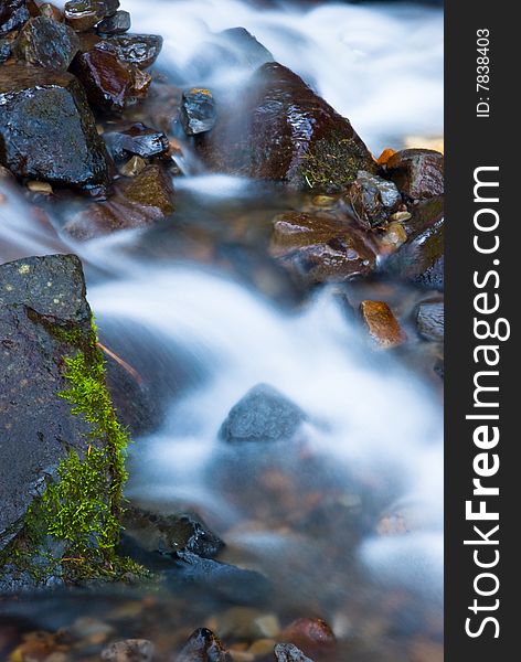 A motion blur shot of water flowing rapidly down a stream. A motion blur shot of water flowing rapidly down a stream.