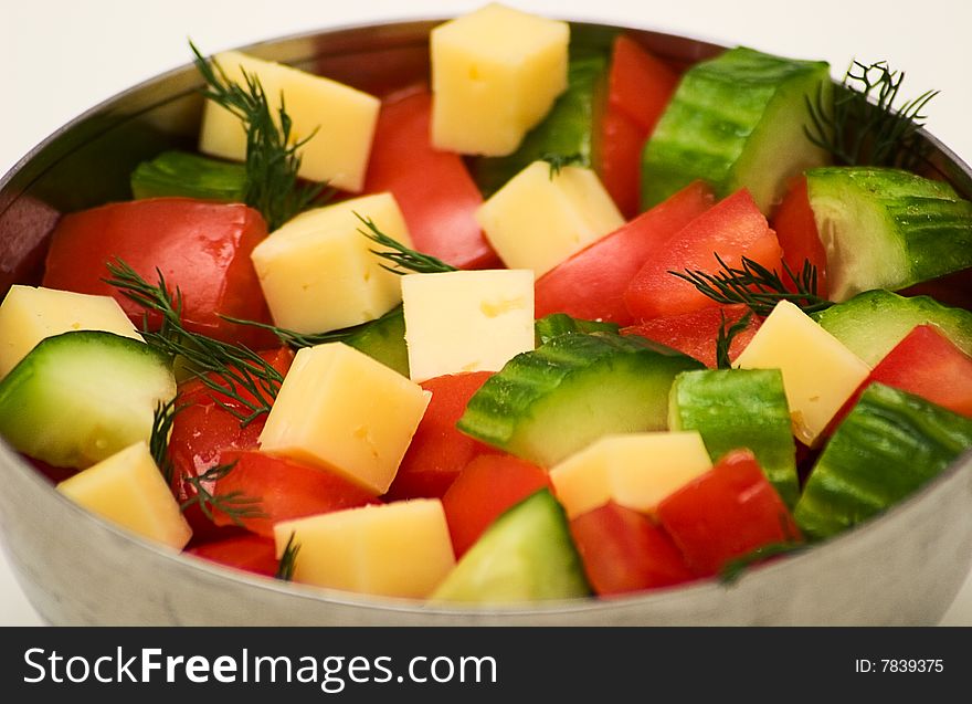 Tomatoes, cucumbers, dill and cheese in the iron bowl. Isolated on a white background. Studio light. Tomatoes, cucumbers, dill and cheese in the iron bowl. Isolated on a white background. Studio light.