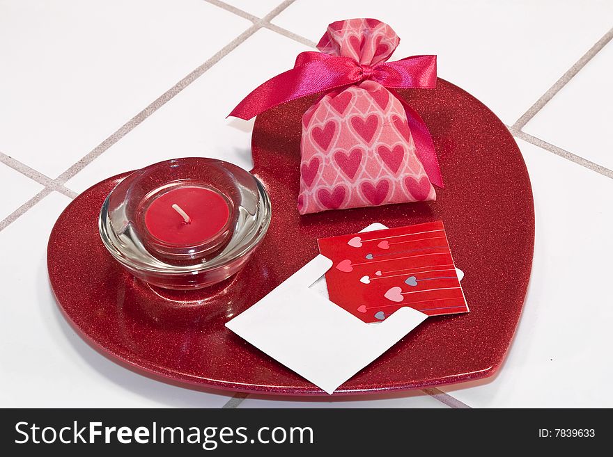 Red metallic heart dish with red candle in holder and valentine sachet with card. Red metallic heart dish with red candle in holder and valentine sachet with card