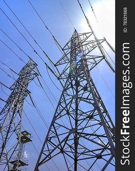 High voltage electrical overhead lines on blue sky