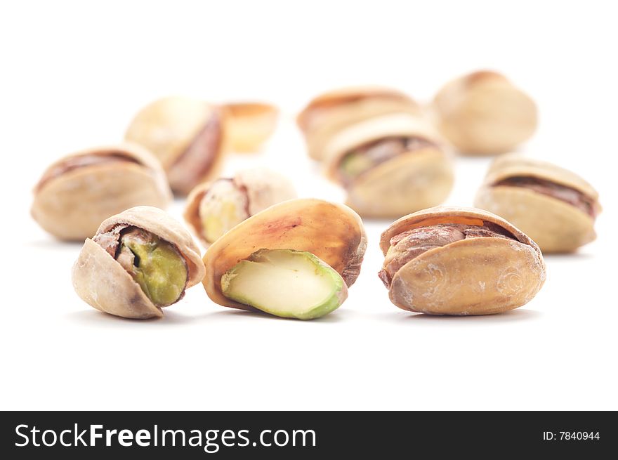 Several pistachios with salt isolated on a white background. Background blurred. Several pistachios with salt isolated on a white background. Background blurred.