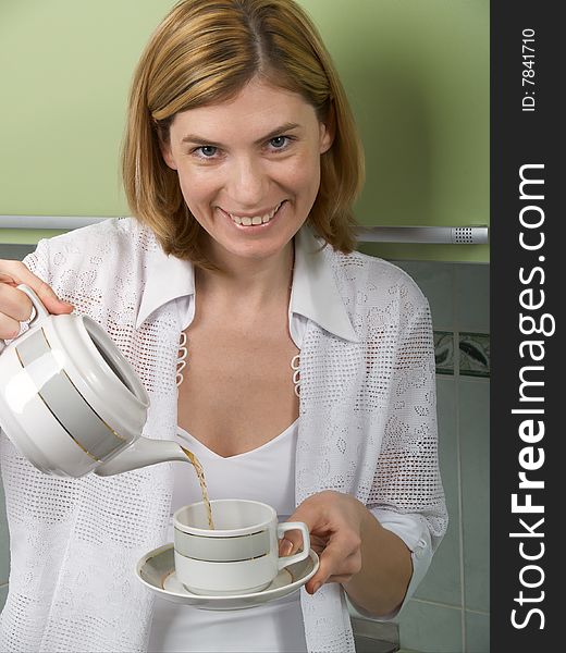 The young girl pours coffee in a cup. The young girl pours coffee in a cup