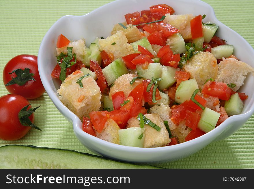 Fresh tomato and cucumber salad with bread cubes on plate