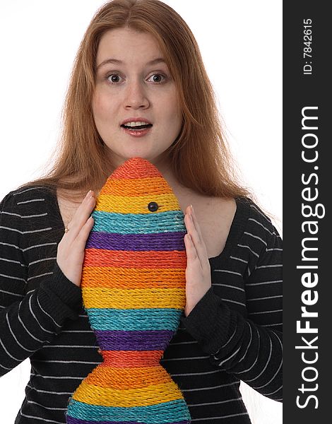The young beautiful woman holds a cheerful toy rainbow fish. The young beautiful woman holds a cheerful toy rainbow fish