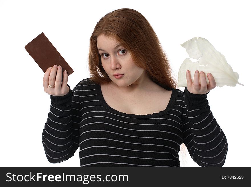 The young woman chooses a diet cabbage or chocolate. The young woman chooses a diet cabbage or chocolate