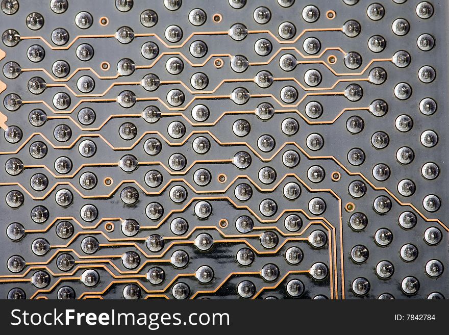 Macro close-up of a detail section of the back of a computer circuit board. This is the area where the PCI slots are located, with rows of soldering points and data pathways along the circuit connections. Macro close-up of a detail section of the back of a computer circuit board. This is the area where the PCI slots are located, with rows of soldering points and data pathways along the circuit connections.