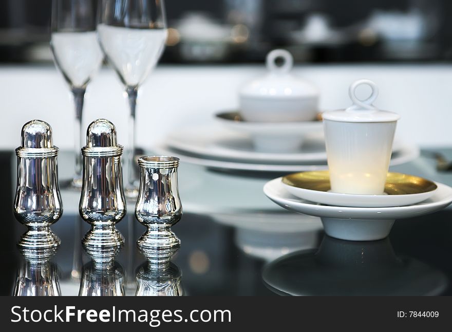 Silver salt and paper set on glass table