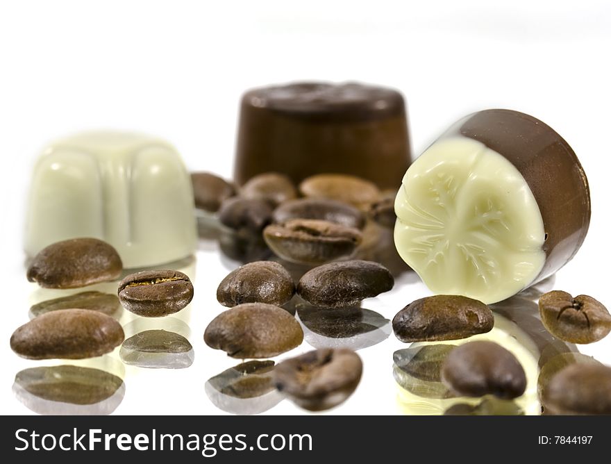 Chocolates and grains of coffee on a smooth surface. Chocolates and grains of coffee on a smooth surface