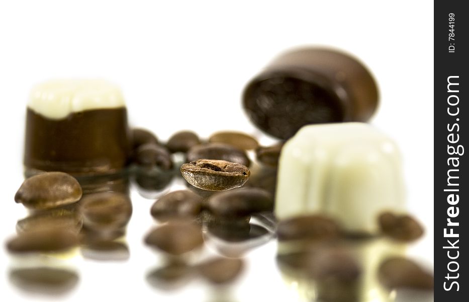 Chocolates and grains of coffee on a smooth surface. Chocolates and grains of coffee on a smooth surface