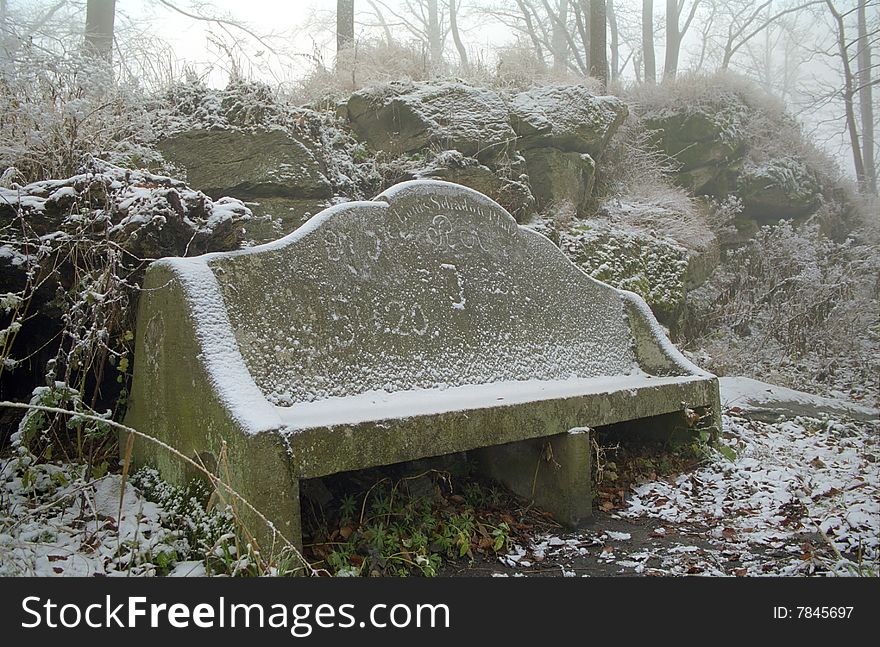 Stone bench in a park - winter time.