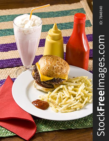 Cheeseburger with fries and strawberry milkshake. Cheeseburger with fries and strawberry milkshake