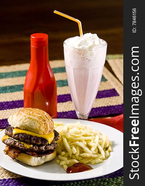 Cheeseburger with fries and strawberry milkshake. Cheeseburger with fries and strawberry milkshake