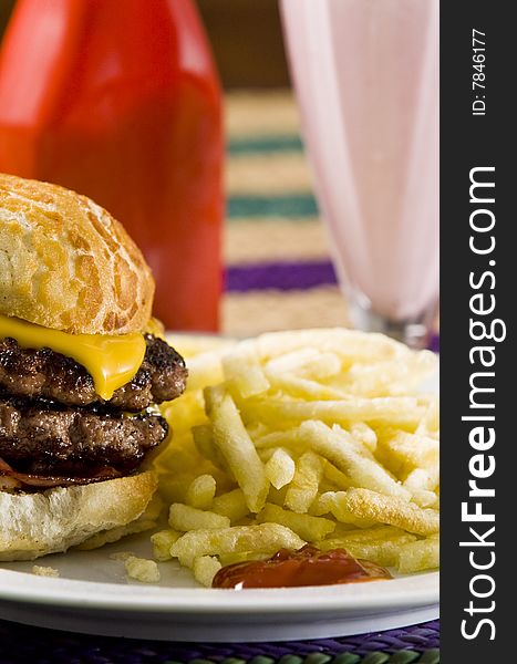 Cheeseburger with fries and strawberry milkshake. Cheeseburger with fries and strawberry milkshake