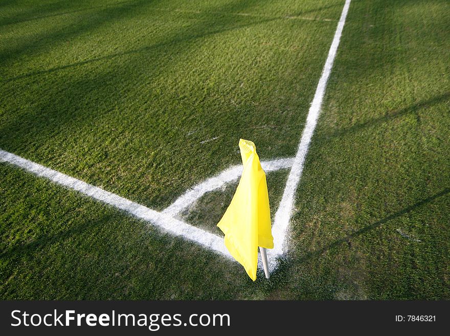 A yellow flag on a football field in a stadium